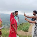 People taking health surveys outdoors in a rural setting with scenic hills.