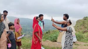 People taking health surveys outdoors in a rural setting with scenic hills.